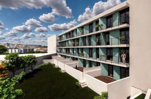 Apartamento T1 com varanda e lugar de garagem em edifício com jardim.