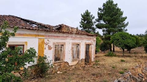 Conjunto de moradias em ruína e terrenos em penhascoso