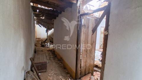 Conjunto de moradias em ruína e terrenos em penhascoso