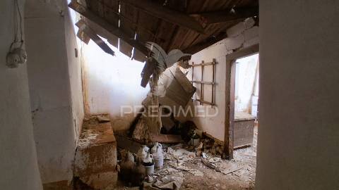 Conjunto de moradias em ruína e terrenos em penhascoso