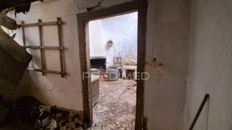 Conjunto de moradias em ruína e terrenos em penhascoso