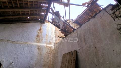 Conjunto de moradias em ruína e terrenos em penhascoso