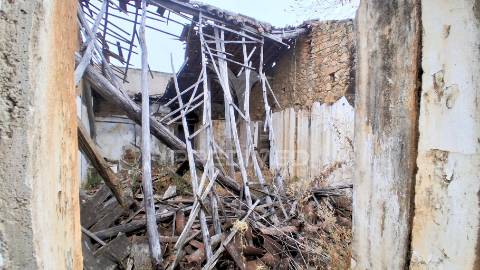Conjunto de moradias em ruína e terrenos em penhascoso