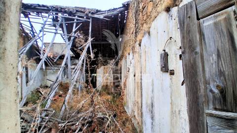 Conjunto de moradias em ruína e terrenos em penhascoso