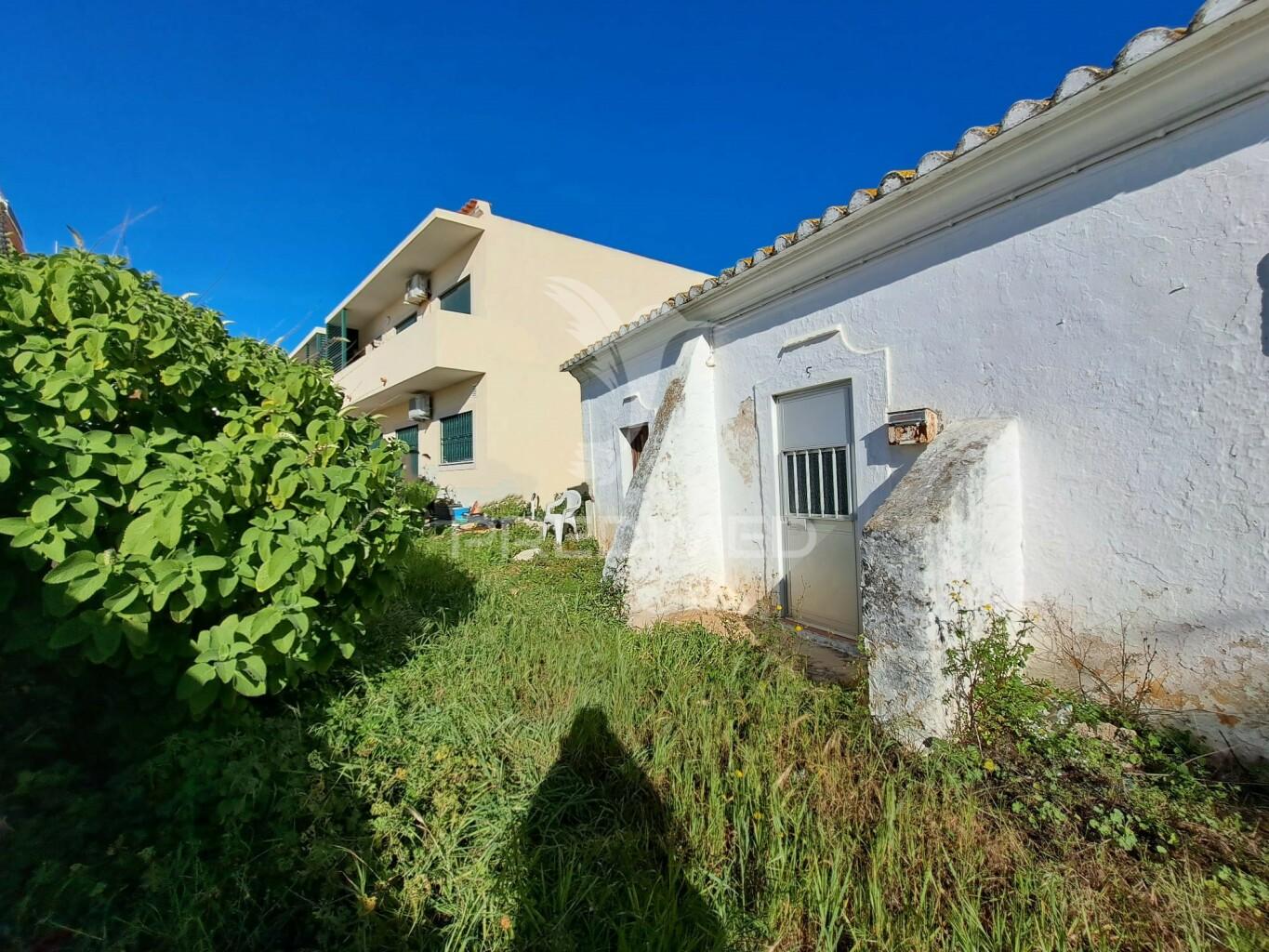 Terreno urbano com construção antiga no centro de quarteira
