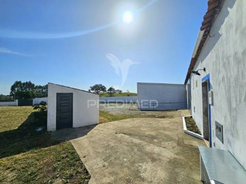Moradia com dois armazéns e terreno