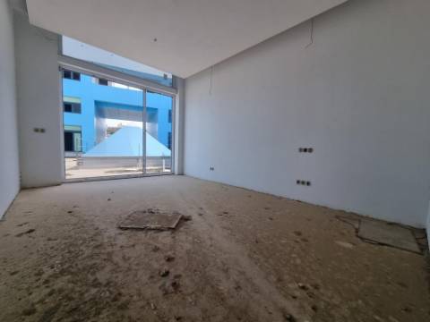 Terreno com prédio por concluir (edifício de habitação e comércio)