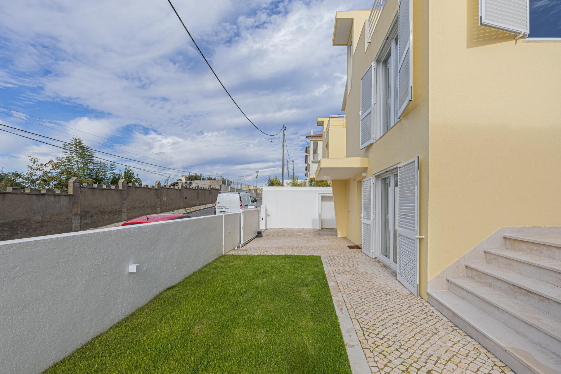 Moradia T5 isolada (A+) com 4 WC, varandas amplas, jardim relvado, garagem e vista desafogada.