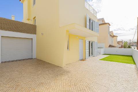 Moradia T5 isolada (A+) com 4 WC, varandas amplas, jardim relvado, garagem e vista desafogada.