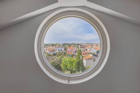 Moradia T5 isolada (A+) com 4 WC, varandas amplas, jardim relvado, garagem e vista desafogada.